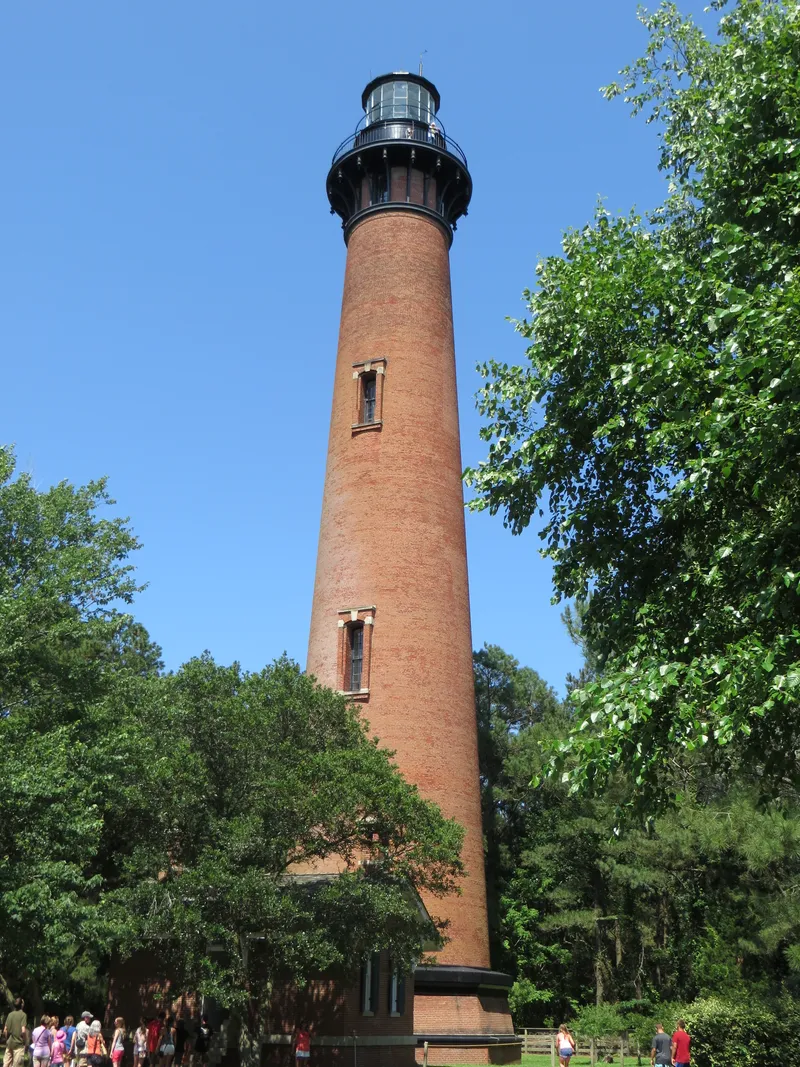 Vertical view of the Currituck Beach Lighthouse in Corolla, showing the full tower from base to lantern room with its distinctive unpainted brick exterior