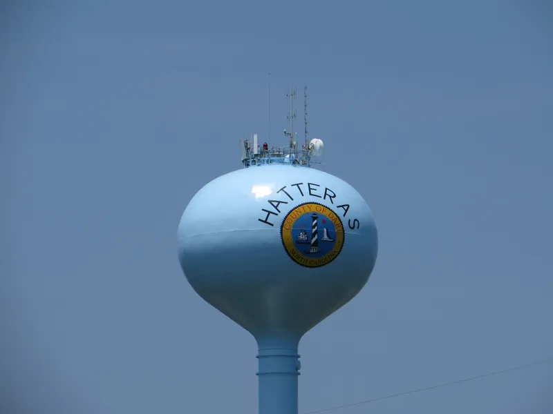 View of Hatteras Island coastline showing beach, dunes, and the village of Hatteras with Pamlico Sound in the background